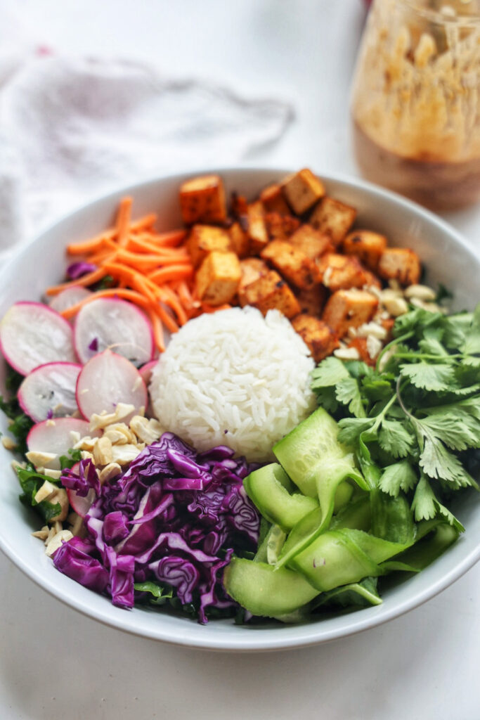 a nourish bowl with a mix of different colorful vegetables and rice.