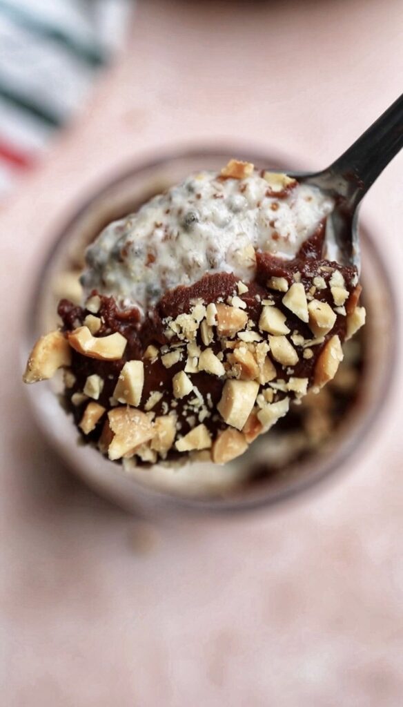 A spoonful of chia pudding with chopped peanuts.

