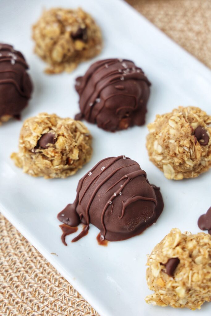 No bake peanut butter oatmeal balls covered in chocolate on a white plate.