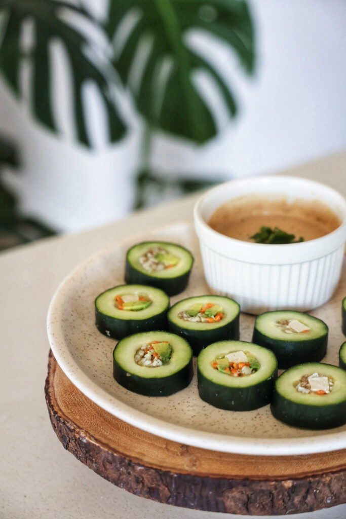A plate of healthy cucumber sushi rolls with tofu and avocado. 