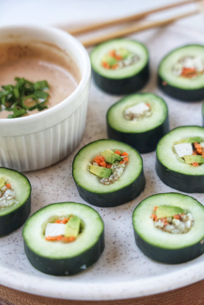 A plate of healthy cucumber sushi rolls with tofu and avocado. 