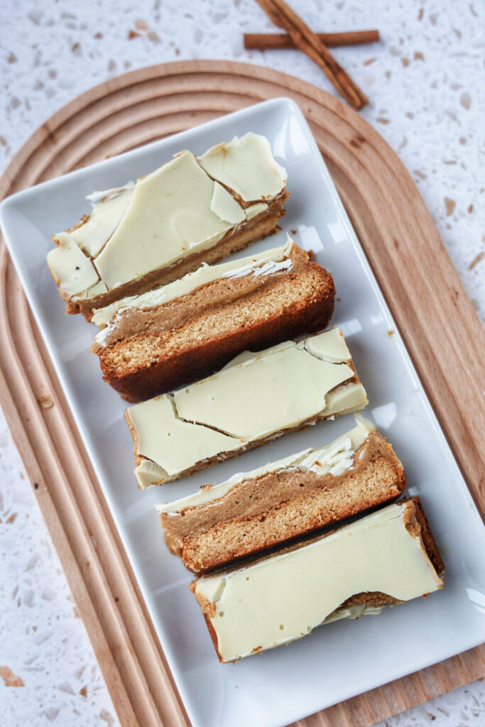 A plate of vegan pumpkin twix bars topped with white chocolate.