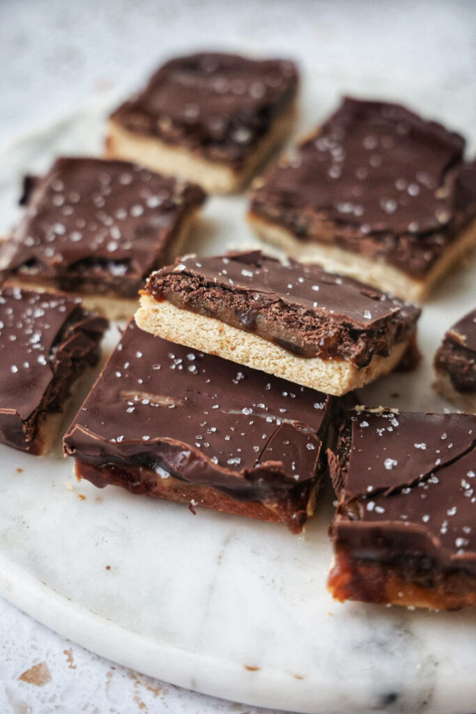 Vegan millionaire's shortbread bars on a marble plate.