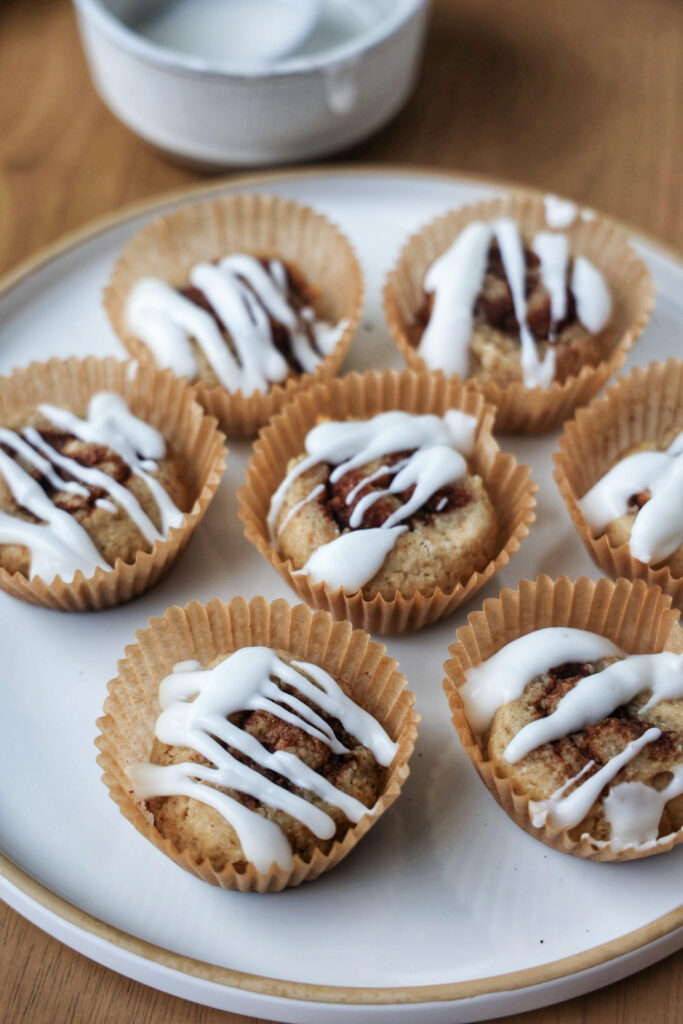 Healthy banana cinnamon rolls on a plate with drizzle.