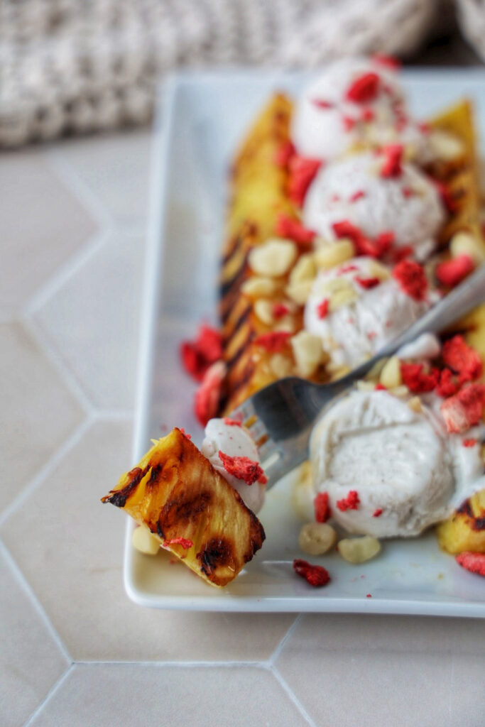 A grilled pineapple split with ice cream on top.