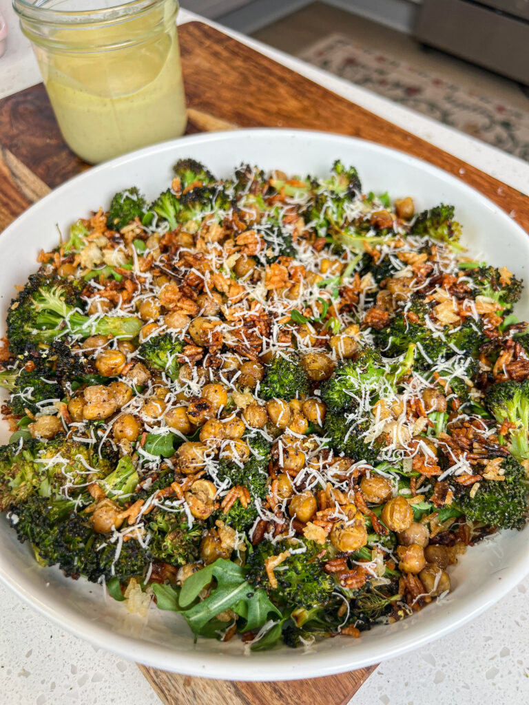 A bowl of roasted broccoli caesar salad with crispy rice.