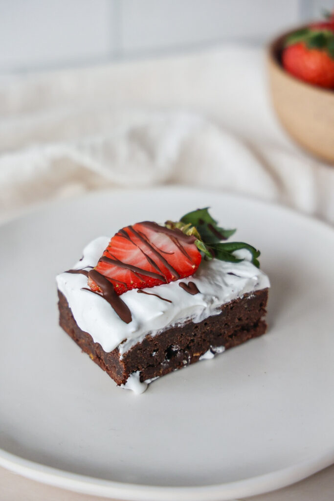 Gluten free brownie with strawberries and whipped cream.
