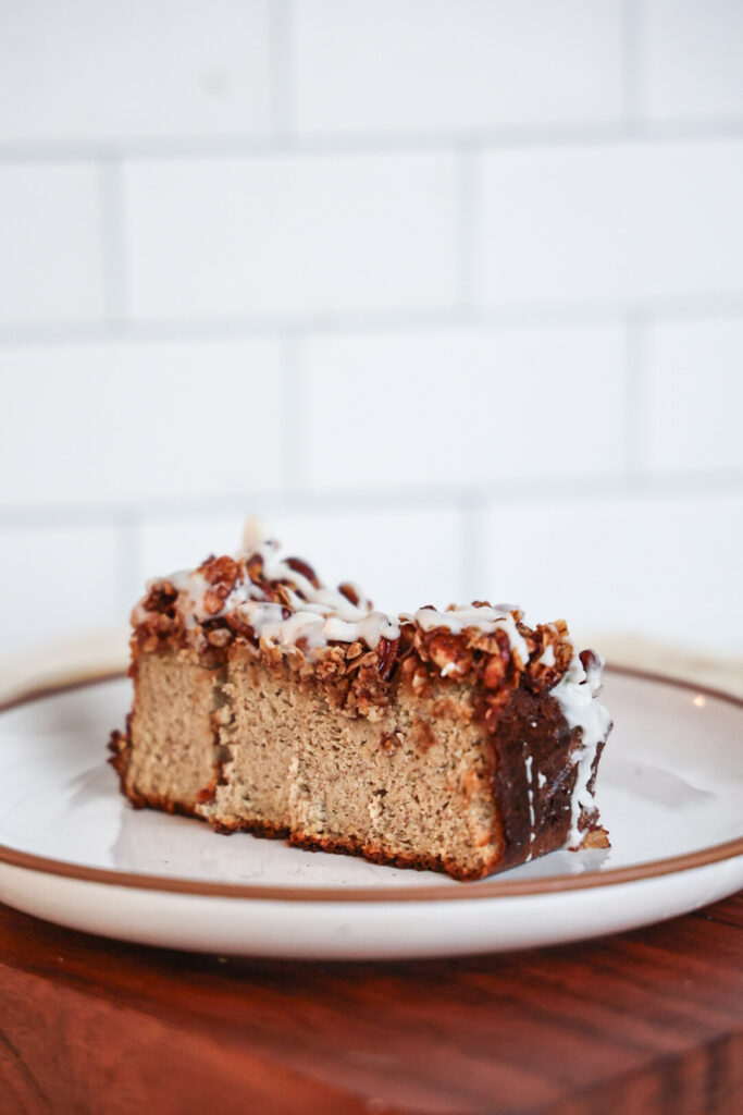 A slice of protein banana bread with streusel topping and glaze.
